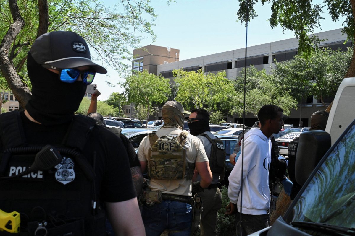 Masked law enforcement officers, including HSI and ICE agents, take people into custody at an immigration court in Phoenix, Arizona, U.S., May 21, 2025.  REUTERS/Caitlin O'Hara