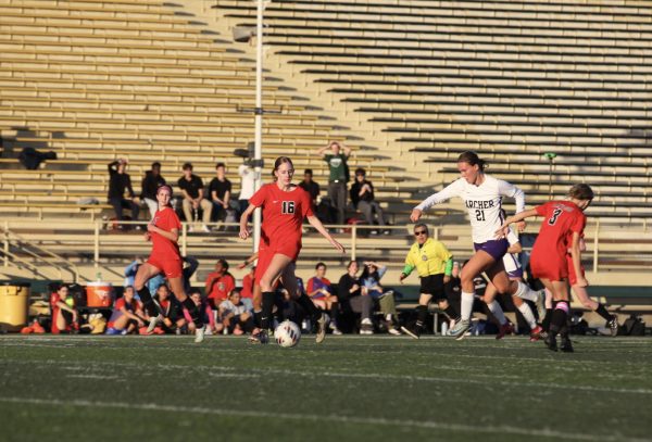 During an Archer varsity soccer game, Jackie Mayne ('28) chases after the ball in a white and purple Archer jersey. After tearing her ACL, Mayne said it was difficult to adjust to a life without the sport she had previously committed so much time to. "I tore my ACL, but I felt very little pain through it all, that was never the hardest part of the recovery process," Mayne said. "Understanding what it meant for me was just a really tough pill to swallow." (Photo courtesy of Archer Athletics)