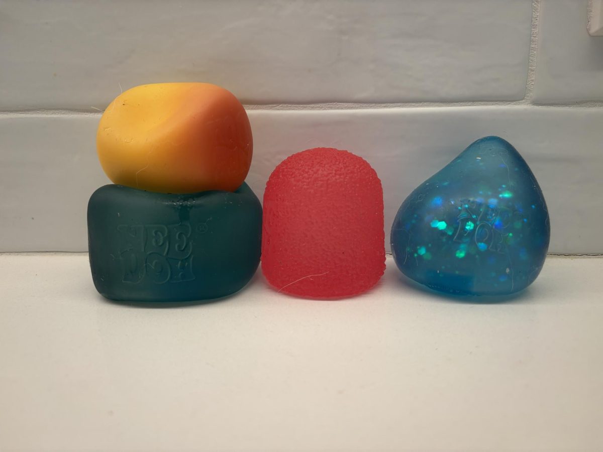 This image depicts five Needohs with varying colors. Needohs are a form of fidget toy, often used as a stress reliever. 